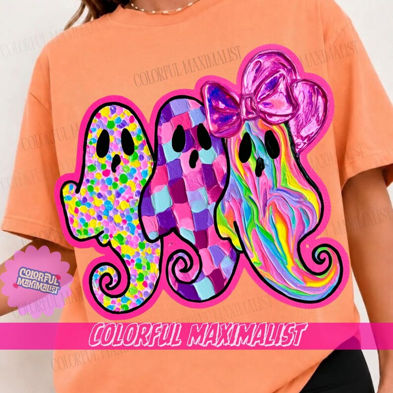 May include: An orange t-shirt featuring a graphic of three ghosts with black eyes and mouths. The first ghost has a multicolored polka dot pattern, the second has a purple and blue checkered pattern, and the third has a pink bow and swirl design.