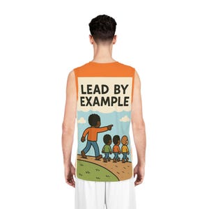 Peut inclure: Débardeur orange et blanc avec le texte "LEAD BY EXAMPLE" et une illustration de dessin animé d'une personne en menant trois autres. L'illustration est placée sur un paysage de ciel et d'herbe.