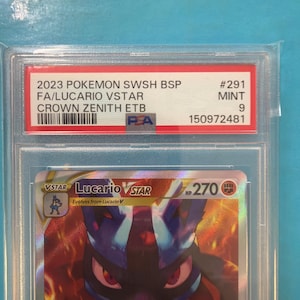 May include: A graded Pok&eacute;mon card featuring Lucario VSTAR. The card is encased in a protective holder with a red and white label that reads "2023 POKEMON SWSH BSP FA/LUCARIO VSTAR CROWN ZENITH ETB." The card is graded as Mint 9.