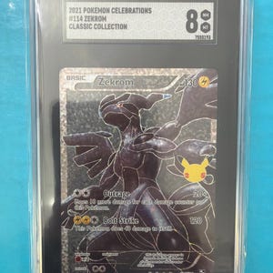 Könnte beinhalten: Eine bewertete Pokémon-Karte mit Zekrom aus der 2021 Pokémon Celebrations Classic Collection. Die Karte ist mit NM-MT 8 bewertet und zeigt eine schwarz-silberne Illustration von Zekrom mit Angriffsdetails und einem Pikachu-Logo.