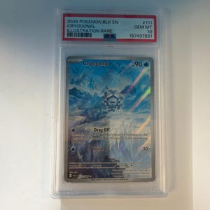 May include: A 2025 Pokemon Cryogonal Illustration Rare trading card, graded GEM MT 10 by PSA. The card features a blue, icy landscape with the character Cryogonal, displaying the attacks Drag Off and Icicle, with 90 HP and card number 111/085.