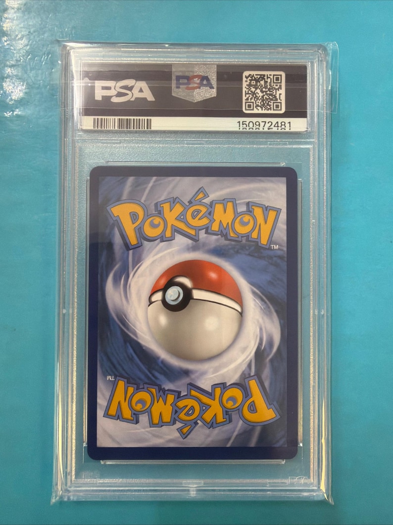 May include: A graded Pok&eacute;mon trading card in a clear plastic case. The card shows the Pok&eacute;mon logo and a Pok&eacute; Ball design on a blue background. The case has the PSA logo and a serial number.
