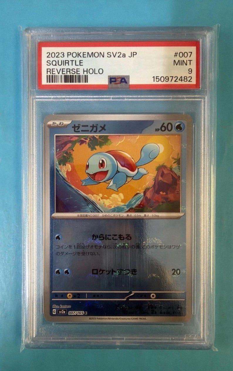 May include: A graded Pok&eacute;mon card featuring Squirtle from the 2023 SV2a JP set. The card is a Reverse Holo, graded a Mint 9 by PA. The card has Japanese text and a blue and orange Squirtle illustration.