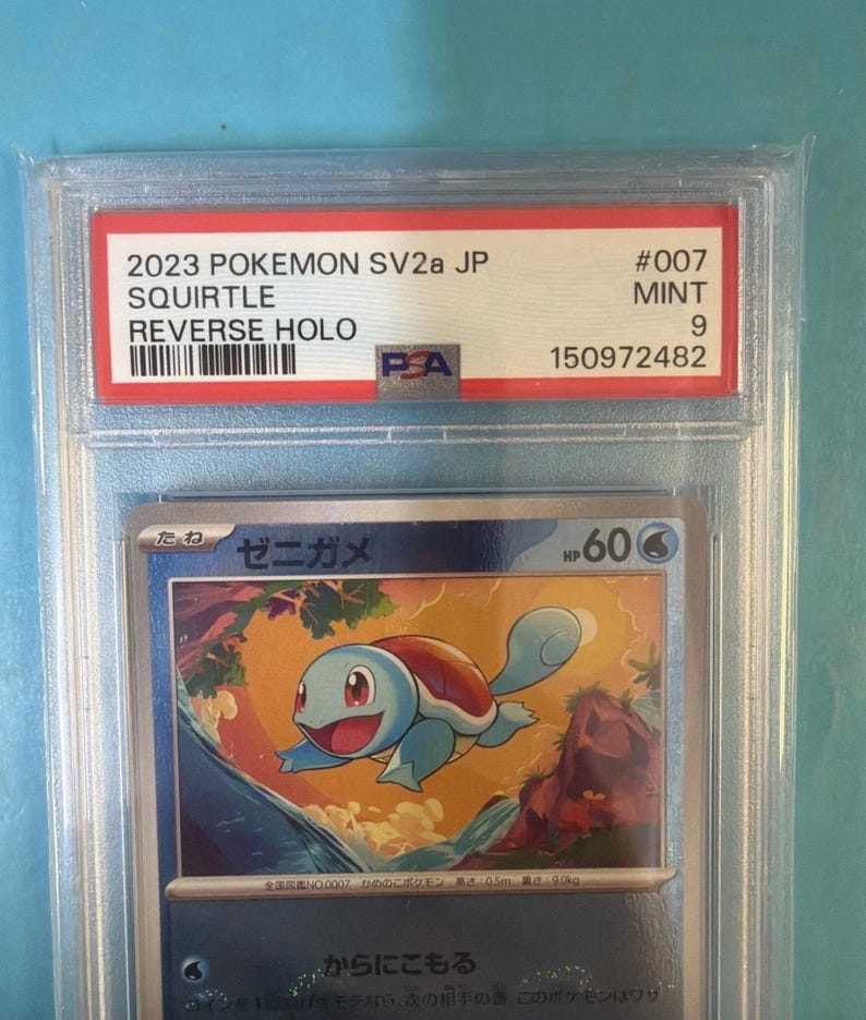 May include: A graded Pok&eacute;mon card featuring Squirtle from the 2023 SV2a JP set. The card is graded a 9 and is a Reverse Holo. The card's text includes "SQUIRTLE" and "REVERSE HOLO". The card is encased in a clear protective holder.