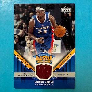 Könnte beinhalten: Basketball-Sammelkarte mit LeBron James in einem blau-roten East All-Star-Trikot mit der Nummer 23. Die Karte enthält den Text "NBA All-Star 2005" und "Authentics Shorts".
