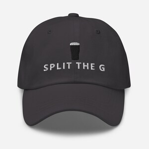 Puede incluir: Gorra de b&eacute;isbol gris oscuro con visera curva. La gorra presenta un dise&ntilde;o bordado de una pinta de cerveza negra y el texto "SPLIT THE G" en blanco. El sombrero est&aacute; hecho de un material suave.