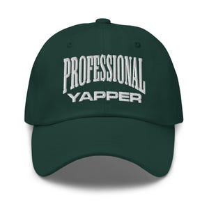 Może przedstawiać: Ciemnozielona czapka bejsbolówka z białym haftem "PROFESSIONAL YAPPER". Czapka ma zakrzywiony daszek i sześciopanelową konstrukcję, idealna do noszenia na co dzień.