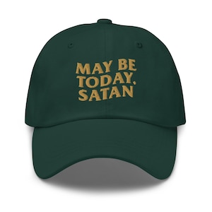 May include: A dark green baseball cap with the embroidered text "MAY BE TODAY, SATAN" in gold. The cap has a curved brim and a fabric strap closure at the back. This hat is a casual accessory.