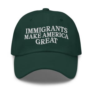 以下が含まれることがあります： 「IMMIGRANTS MAKE AMERICA GREAT」の白い刺繍が施された、濃い緑色の野球帽。 つばがカーブしており、丸みを帯びたクラウンが特徴で、典型的な野球帽のスタイルです。