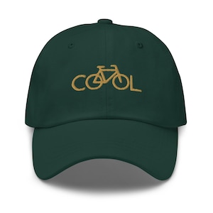 May include: A dark green baseball cap with the word "COOL" embroidered in gold thread. The "O" in "COOL" is replaced with a bicycle graphic. The cap has a curved brim and a button on top.