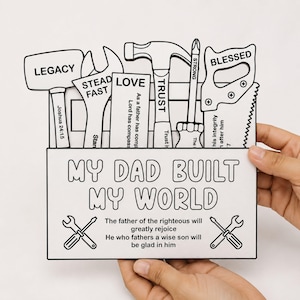May include: A white wooden cutout sign shaped like a toolbox filled with tools including a hammer, wrench, and saw. The front features the text 'MY DAD BUILT MY WORLD' and religious verses. Each tool is labeled with words like 'LEGACY', 'STEADFAST', 'LOVE', 'TRUST', 'STRONG', and 'BLESSED'.