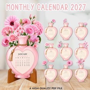 May include: A 2027 monthly calendar featuring heart-shaped pink perfume bottles as monthly pages. Each bottle displays a month, calendar dates, and floral illustrations. The January page is displayed on a wooden stand, with the text MONTHLY CALENDAR 2027.
