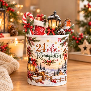 May include: A cylindrical container featuring the text 24 süße Kleinigkeiten, decorated with a winter landscape, a lantern, and a robin. The top is filled with a candy cane, a small gift, a miniature lantern, and pine branches.