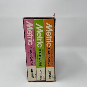 May include: A set of three Metric Flash Cards in a box, featuring pink, green, and orange spines. The cards are labeled Weight No. 267, Volume No. 268, and Length No. 266. Each card set includes the text Metric Flash Cards and copyright information.