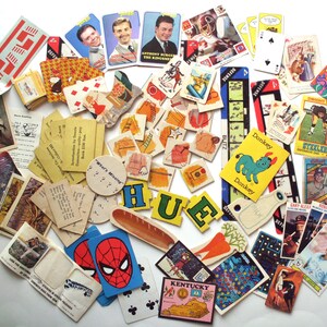 May include: A collection of vintage ephemera, including playing cards, trading cards, and paper cutouts. The items feature various images, including portraits, sports figures, and cartoon characters. Some items have text, including the word "HUE".