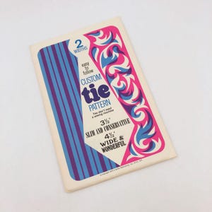 May include: Vintage custom tie pattern booklet. The cover features a design with pink, blue, and white swirls and stripes. The text indicates the pattern is easy to follow and offers two widths: 3.5 inches and 4.5 inches.