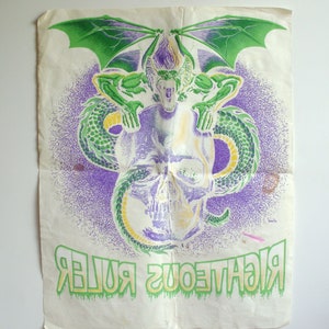 May include: Vintage poster with a central skull design, overlaid with a green and purple creature with wings and a serpent. The words "RIGHTEOUS RULER" are printed in green at the bottom. The poster has a distressed, aged appearance.