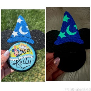 May include: A black glittery Mickey Mouse ear headband with a blue wizard hat featuring white stars and a crescent moon. A button with Mickey Mouse, the text "Happy Birthday!" and the name "Kelly" is attached.