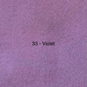 Puede incluir: Primer plano de un trozo de tela violeta. La tela tiene una superficie texturizada y el color es un púrpura suave y apagado. El texto "33 - Violet" está impreso en negro en la esquina superior izquierda.