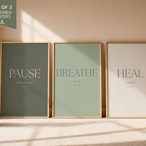 May include: A set of three rectangular posters in light wooden frames. The first poster is dark sage green with the text PAUSE For a moment. The second is light sage green with BREATHE Slowly. The third is off-white with HEAL Forever.