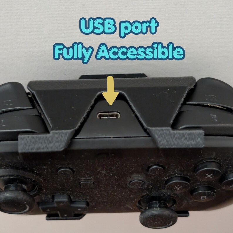 May include: Close-up of a black game controller with the text "USB port Fully Accessible" in blue and a yellow arrow pointing to the USB port. The controller has various buttons and joysticks.
