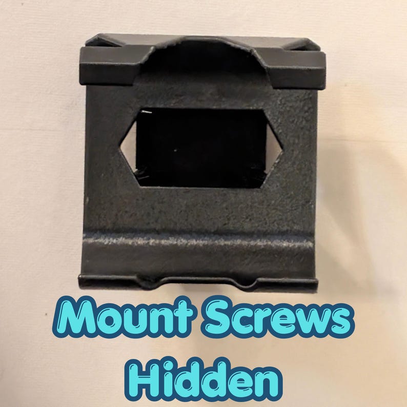 May include: A black metal bracket with a rectangular shape and a hexagonal opening. The bracket has a textured surface and the text "Mount Screws Hidden" in a blue and white font.