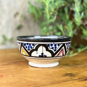 May include: A set of three ceramic mugs with a speckled, matte finish. The mugs are in cream, light grey, and dark grey. Each mug has a simple, minimalist design and a rounded handle.