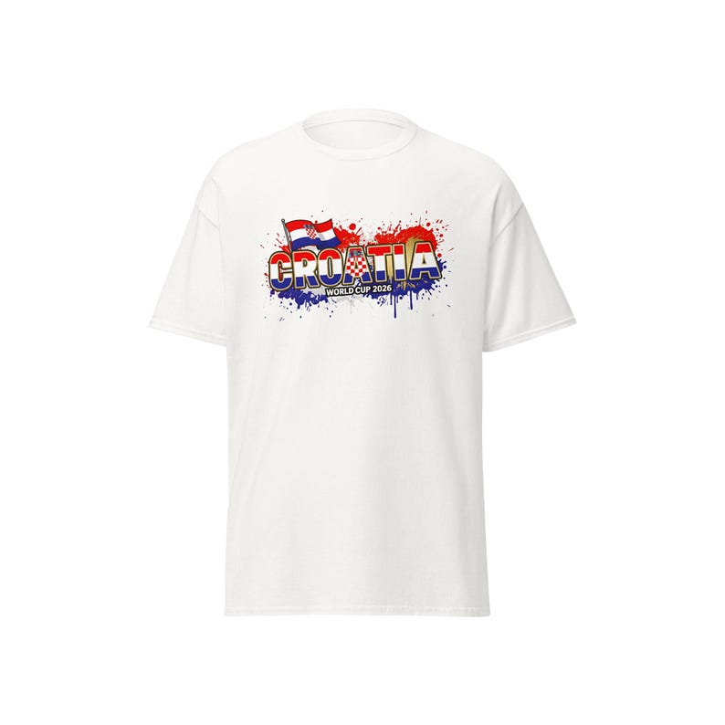 Pu&ograve; includere: T-shirt bianca con la scritta "CROATIA" in un design colorato e stilizzato, con la bandiera croata e la scritta "WORLD CUP 2026". Il design include effetti di schizzi di vernice rossa, blu e bianca.