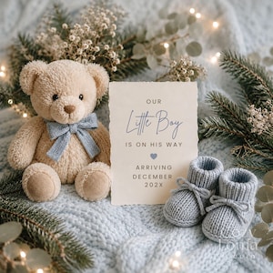 Pode incluir: Um urso de peluche bege com um laço azul claro, um par de sapatinhos de bebé tricotados em azul claro e um cartão de anúncio retangular com o texto: OUR Little Boy IS ON HIS WAY, ARRIVING DECEMBER 202X, decorado com um pequeno coração azul.