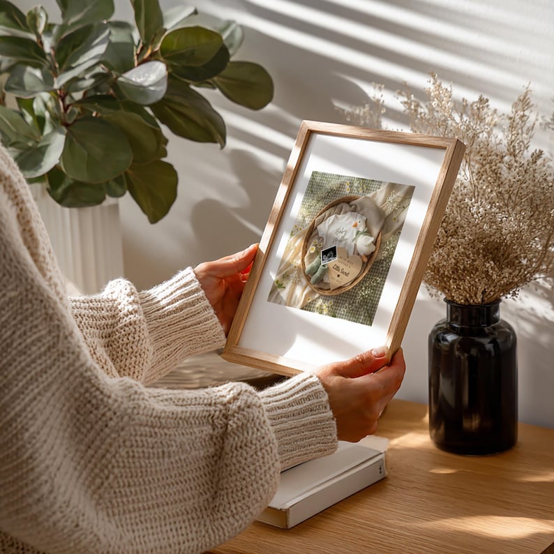 Lifestyle image of a person holding a framed Sage Green Boho baby announcement to demonstrate the scale and high-quality print of the Digital Download.