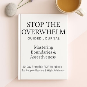 Op de afbeelding: Een wit boek met de titel "STOP THE OVERWHELM" met de ondertitel "Guided Journal" en de tekst "Mastering Boundaries & Assertiveness". Het boek wordt vergezeld door een kopje thee, lavendel takjes en een gladde steen.