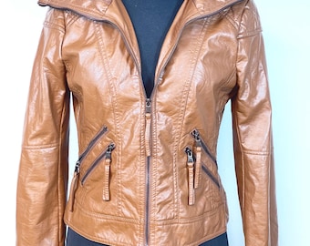 May include: A brown faux leather jacket with a knit collar and multiple zippered pockets. The jacket is displayed on a black mannequin and features a full-length zipper closure. The jacket's color is a warm, medium brown.