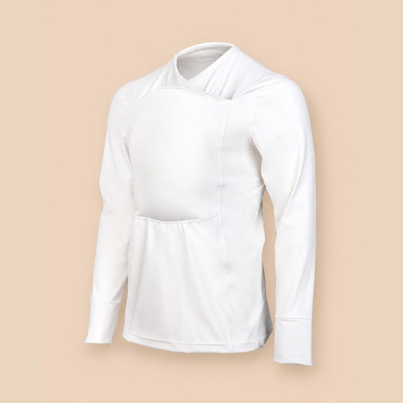 May include: A solid white long-sleeve shirt featuring a wrap-style neckline and a large, rectangular front panel overlay. The garment has fitted sleeves with cuffs and a smooth, opaque fabric construction, presented in a clean, minimalist design.