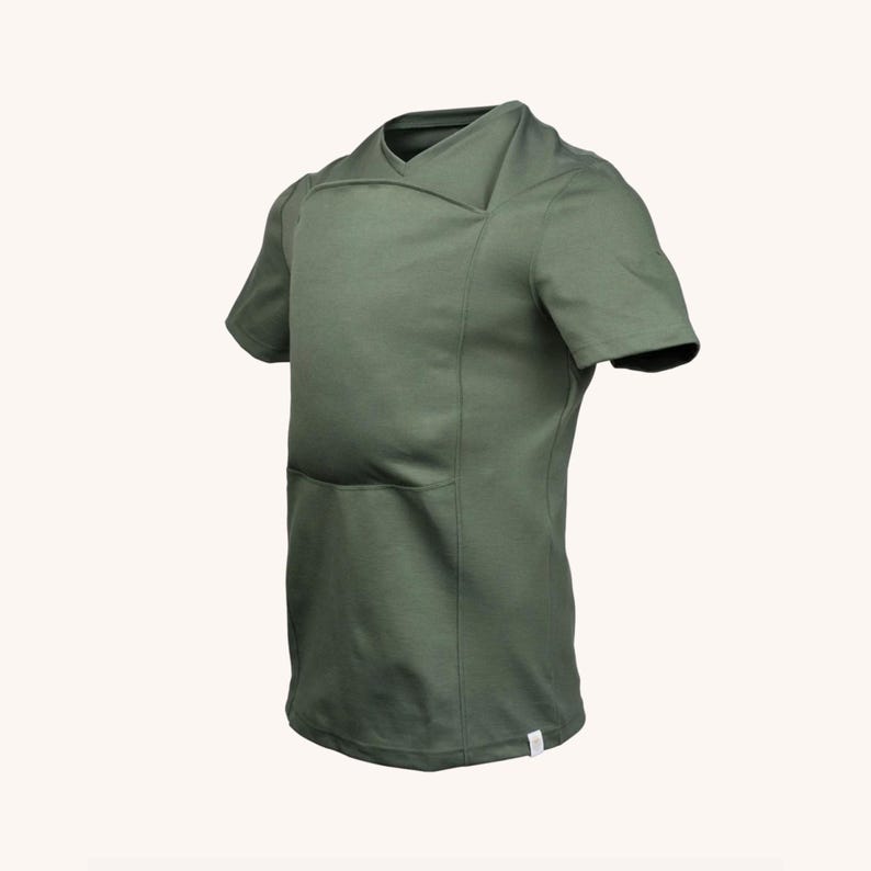 Op de afbeelding: Een olijfgroen t-shirt met korte mouwen, voorzien van een uniek overlappend V-halsontwerp en een gestructureerd voorpaneel. Het kledingstuk heeft een strakke, effen afwerking met een klein wit rechthoekig label aan de onderkant van de zoom.