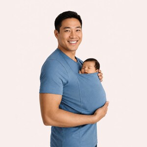 Peut inclure: Un t-shirt bleu &agrave; manches courtes dot&eacute; d'une poche en tissu int&eacute;gr&eacute;e sur la poitrine, con&ccedil;ue pour maintenir un nouveau-n&eacute; en toute s&eacute;curit&eacute; contre le torse. Le v&ecirc;tement est fabriqu&eacute; dans un tissu uni, lisse et extensible.