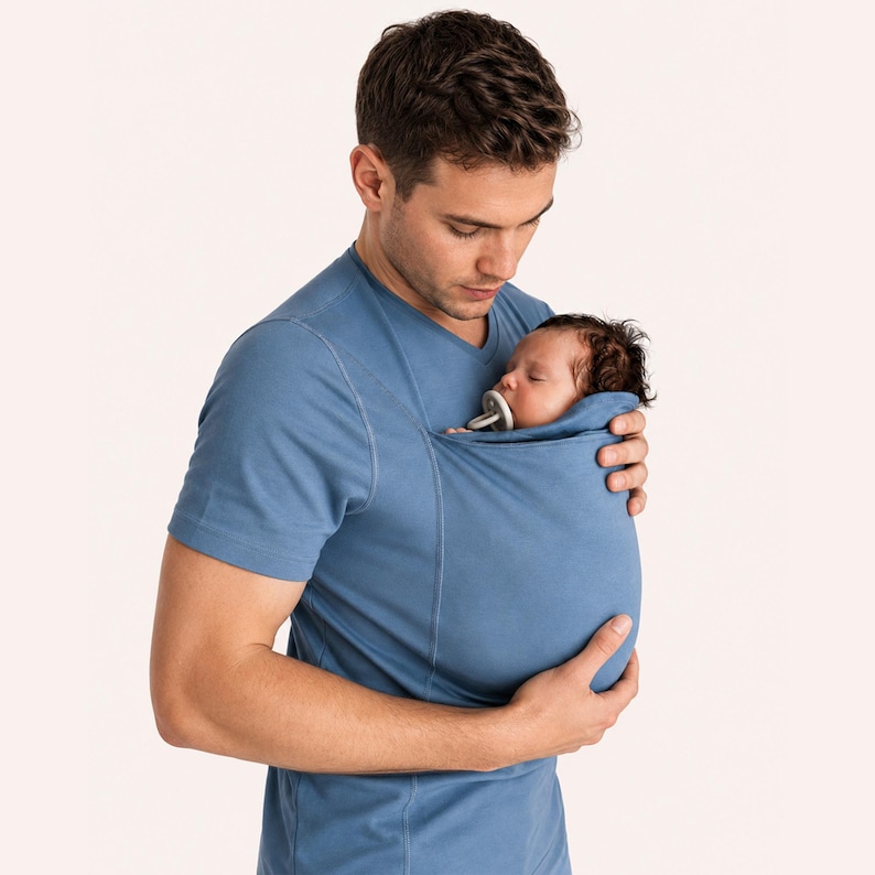 Peut inclure: Un t-shirt bleu &agrave; manches courtes et col en V dot&eacute; d'une poche en tissu int&eacute;gr&eacute;e sur la poitrine, con&ccedil;ue pour maintenir un nourrisson contre le torse. Le v&ecirc;tement est fabriqu&eacute; dans un tissu bleu uni avec des coutures apparentes.