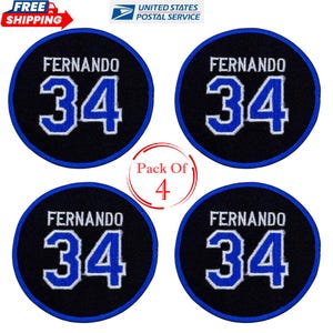 Puede incluir: Cuatro parches circulares con el nombre "FERNANDO" en blanco sobre el número "34" en azul. Los parches tienen un fondo negro con un borde azul. También se ve el texto "Pack Of 4".
