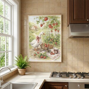 May include: A framed print depicts a white goose with a red bow, a wheelbarrow, and a basket filled with strawberries. The scene includes a white picket fence, a small house, and strawberry plants. A jar of jam sits on a checkered cloth.