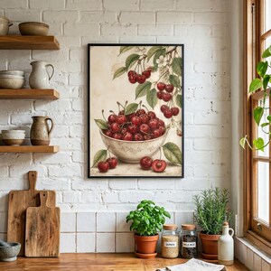May include: A framed print featuring a bowl overflowing with ripe red cherries. The cherries are depicted with green leaves and stems, set against a vintage-style background. The artwork is framed in a black border, adding a classic touch to the kitchen decor.