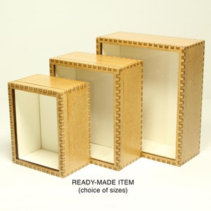 May include: Three wooden boxes of varying sizes, arranged from smallest to largest. The boxes are light brown with a white interior and a decorative notched edge. The text "READY-MADE ITEM (choice of sizes)" is visible at the bottom.