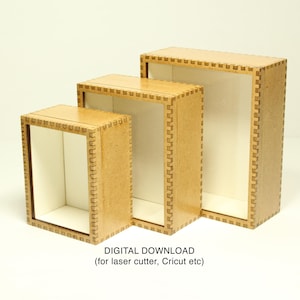 May include: Three wooden shadow boxes of different sizes, with a decorative border. The boxes are made of light brown wood and have a white interior. DIGITAL DOWNLOAD (for laser cutter, Cricut etc) is written below the boxes.