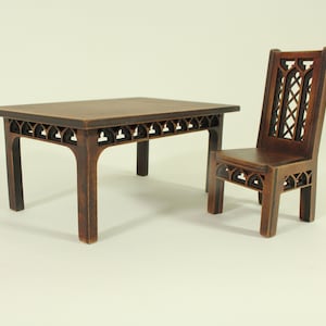 Può includere: Un set da tavolo e sedia in legno marrone scuro con dettagli intagliati intricati. Il tavolo ha un piano rettangolare e quattro gambe con un design decorativo. La sedia ha uno schienale alto e una seduta intagliata.
