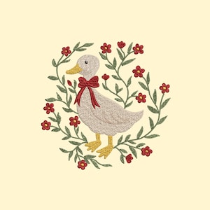 May include: Embroidered design of a duck wearing a red bow, surrounded by a wreath of green leaves and red flowers. The duck has a yellow beak and feet. The background is a soft yellow.