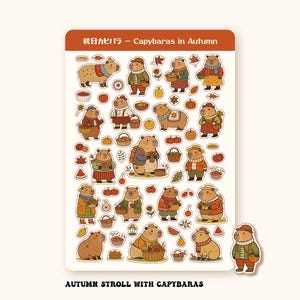 May include: A sticker sheet titled 秋日カピバラ – Capybaras in Autumn featuring numerous illustrations of capybaras wearing autumn clothing, carrying baskets of fruit, and surrounded by pumpkins, leaves, and apples. The text AUTUMN STROLL WITH CAPYBARAS is printed below the sheet.