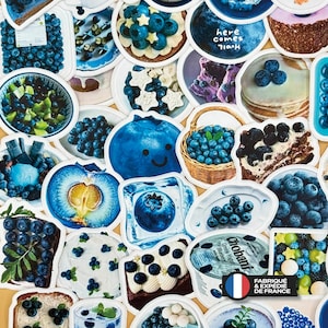 May include: A collection of assorted stickers featuring various blueberry-themed imagery, including fresh blueberries, blueberry pancakes, cakes, yogurt cups with the text Chobani, and a blue fruit character with a smiling face, all arranged in a dense collage.