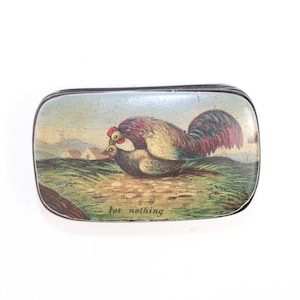 May include: A vintage tin box with a colorful illustration of two chickens, one on top of the other, with the text "for nothing" printed on the bottom.