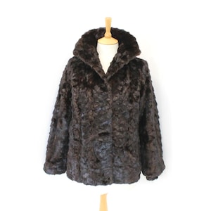 May include: A dark brown faux fur coat with a wide collar and button closure. The coat is displayed on a mannequin against a white background. The fur has a textured appearance.