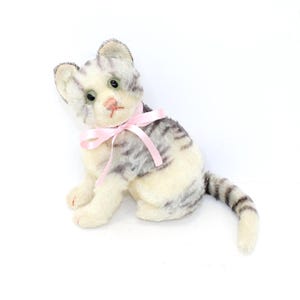 Puede incluir: Una taza de cerámica blanca con asa negra y el texto "But First, Coffee" en negro, con fuente de estilo manuscrito. La taza está sobre una superficie blanca.