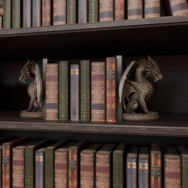 Op de afbeelding: Bronzen drakenboekensteunen op een donkere houten plank, met een rij antieke boeken ertussen. De drakenbeelden hebben gedetailleerde vleugels en schubben. De boeken zijn gebonden in verschillende kleuren, met gouden accenten.