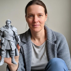 May include: A light gray, unpainted 3D printed figurine of a warrior in detailed plate armor. The figure stands in a neutral pose, wearing a breastplate, pauldrons, gauntlets, and a long cape. The character has short, styled hair and a focused expression.